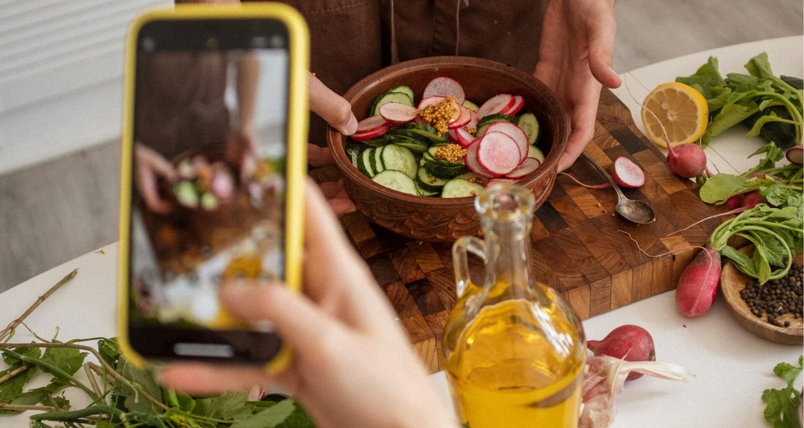 A hand holding a smart taking a photo for a blog. Feature image for How to Start a Blog Without Using Social Media