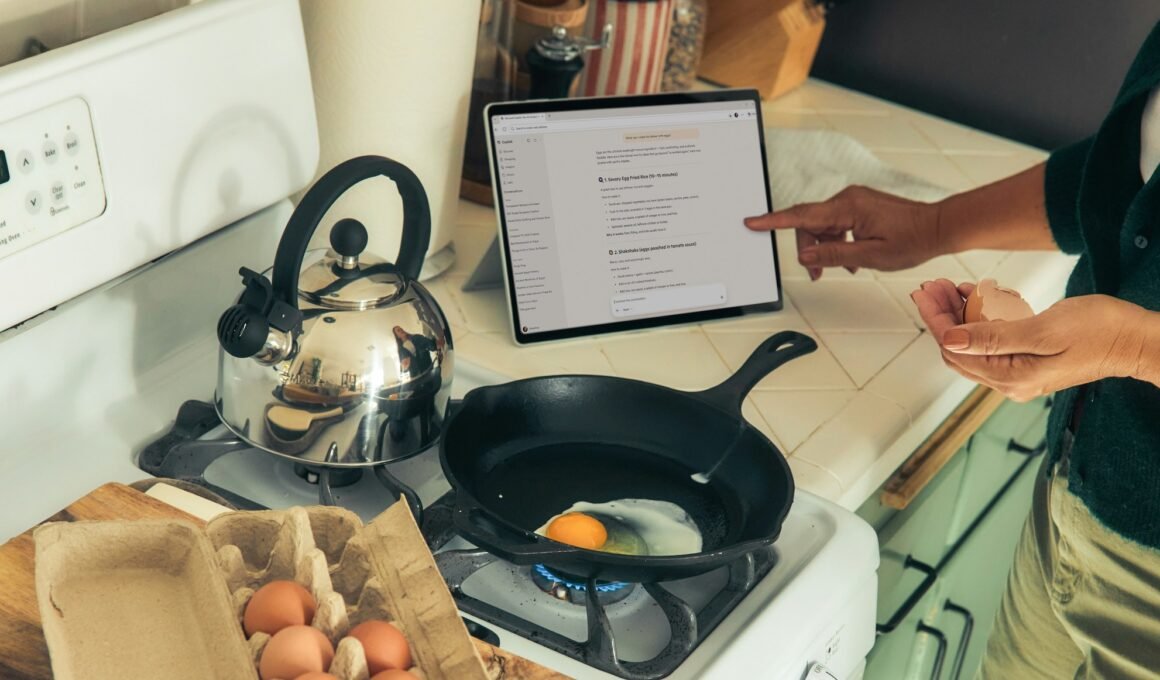 image of woman pointing at ipad following instructions or information about cooking on stove top, in front of stove with cast iron pan frying an egg.