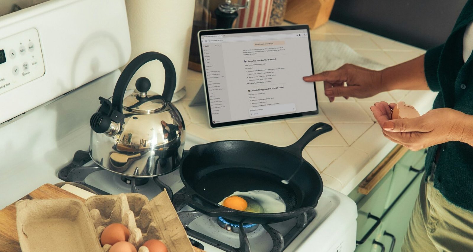 image of woman pointing at ipad following instructions or information about cooking on stove top, in front of stove with cast iron pan frying an egg.
