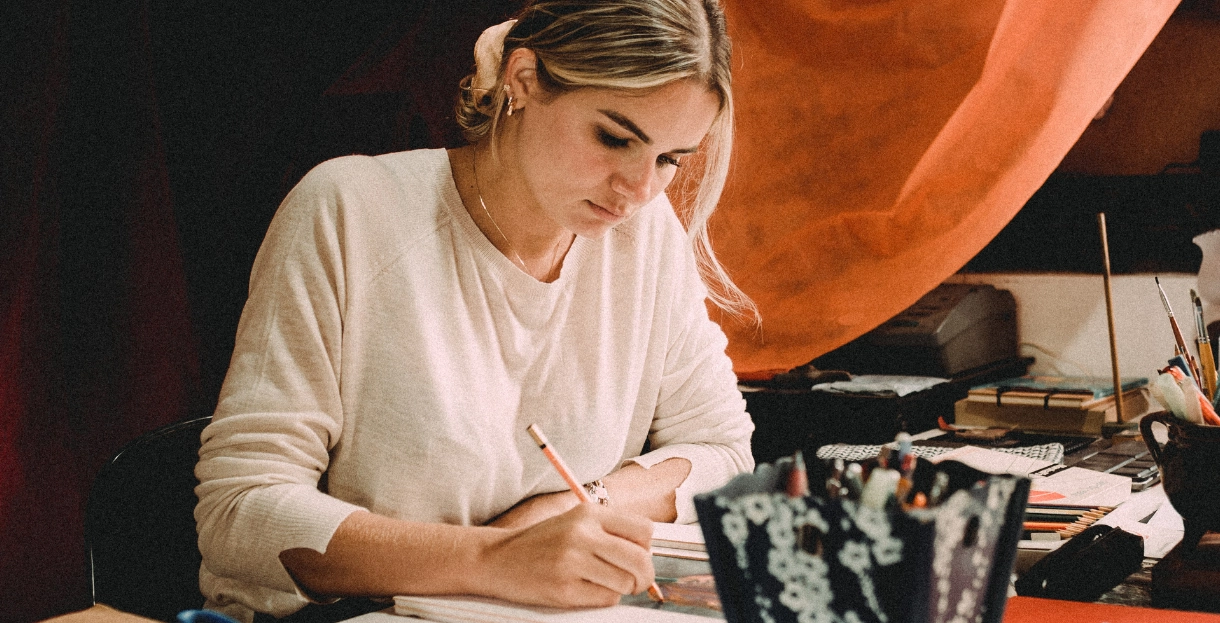 White woman sitting and drawings for the artivle: Career Advice: Find a career path that feels natural, not one you're supposedly 'good at'.