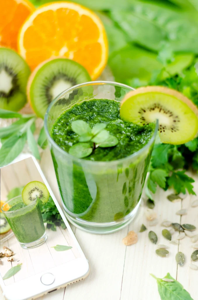 glass of green juice surrounded by fruits and seeds denoting Clear Eczema Naturally: Best Foods for Healthy Skin