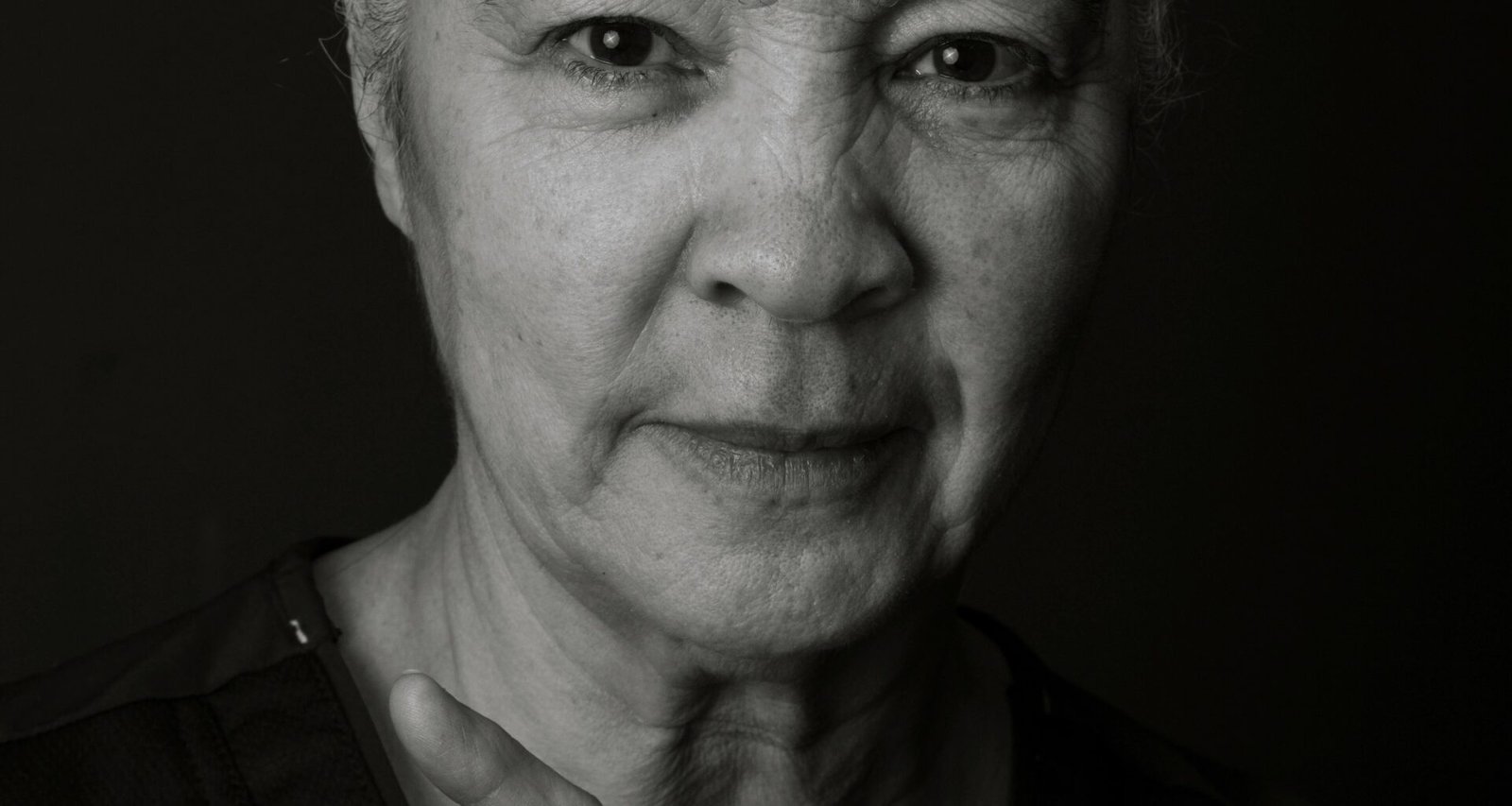 Black and white photo of an older, mixed race woman aging unapologetically.